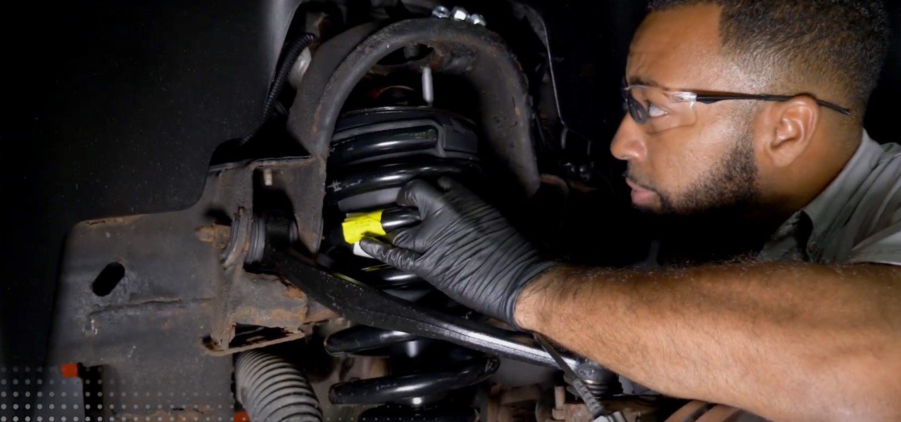 Closeup of a technician installing a Monroe shock on a vehicle